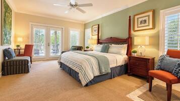 A bedroom with a four-poster bed, a nightstand, a chair, and a window with blinds.