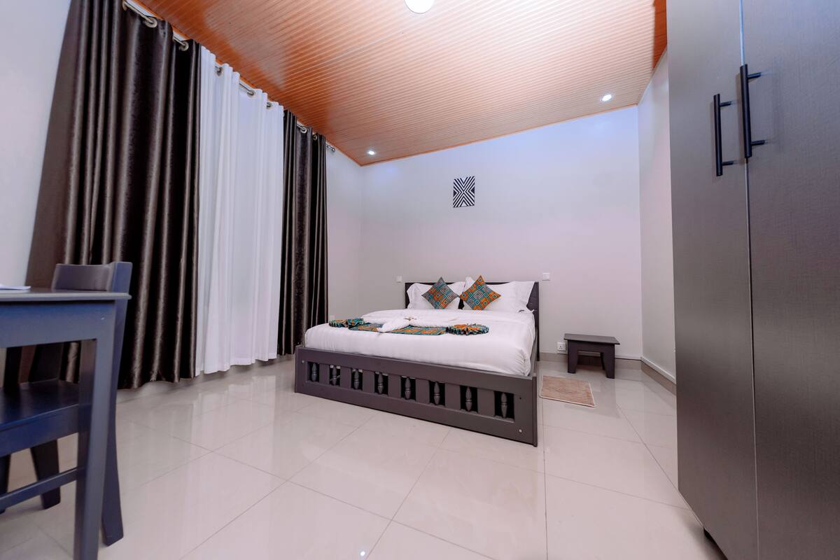 Une chambre à coucher comprenant un lit, un bureau, une armoire et une petite table.