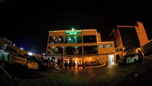 Un hôtel avec une enseigne indiquant « Shaste City Hotel », plusieurs étages et un parking rempli de voitures.