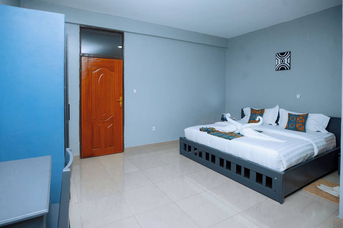 Une chambre à coucher avec un lit, une armoire et une porte.
