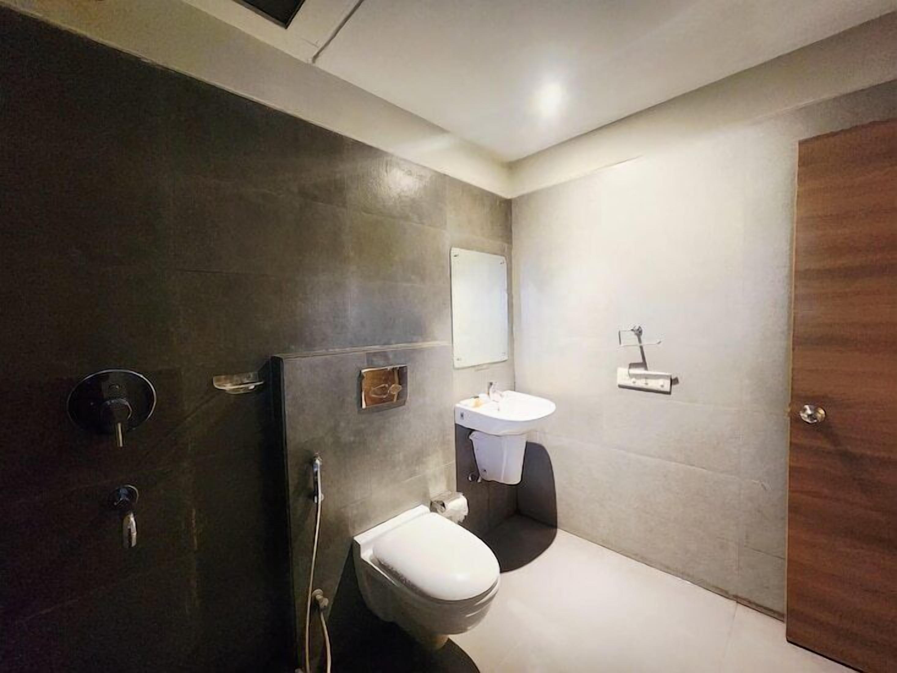 Et moderne badeværelse med toilet, vask og bruser.