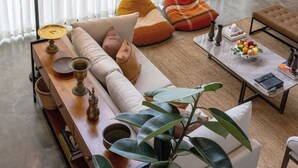 A living room with a sofa, coffee table, and a lamp. There are cushions and a plant on the sofa. - Tranquil Villa in Colombo Suburbs (Moratuwa)