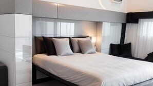 Une chambre moderne avec un grand lit, une armoire intégrée et un appareil de climatisation.