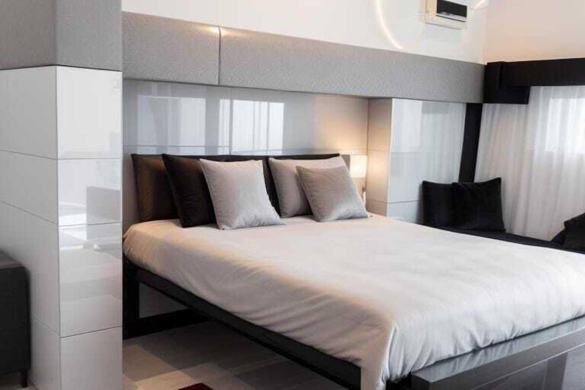 Ein modernes Schlafzimmer mit einem großen Bett, einem eingebauten Kleiderschrank und einer Klimaanlage.