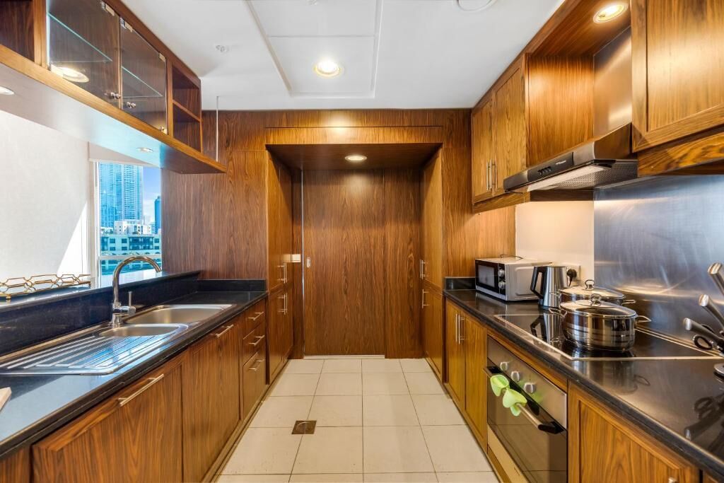 A modern kitchen with wooden cabinets, stainless steel appliances, and a view of the city.