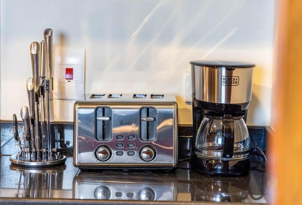 Eine Küche mit Toaster, Kaffeemaschine und einem Besteckeinsatz.