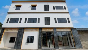 A multi-story building with a white facade, large windows, and a modern design. - Collection O 94762 Starlight  (Pekanbaru)