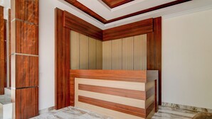A bedroom with a wooden headboard, marble flooring, and a built-in bench. - Collection O 94762 Starlight  (Pekanbaru)