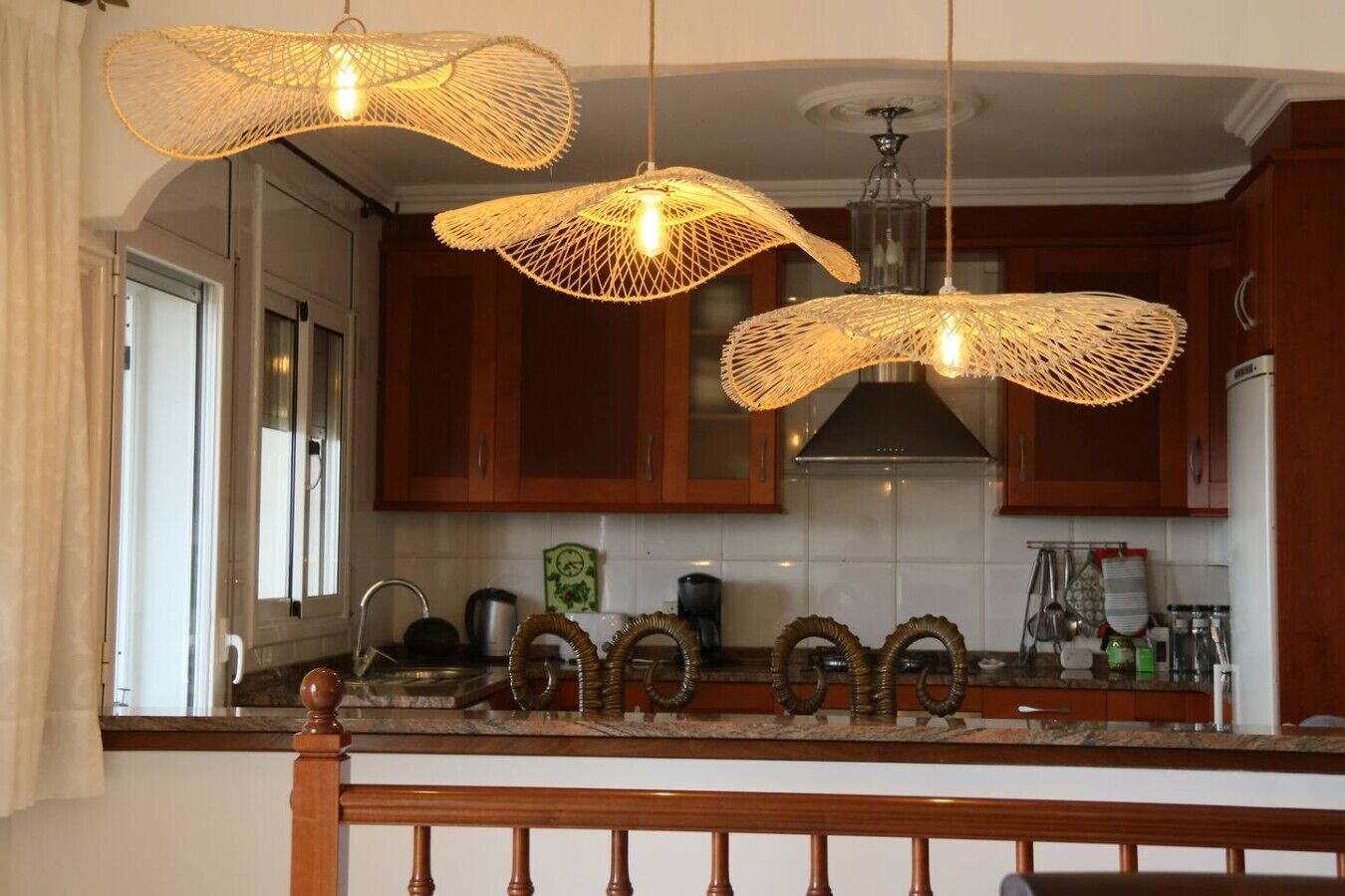 A kitchen with wooden cabinets, a stainless steel range hood, and a marble countertop.