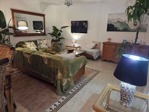Una habitación con una cama, un televisor, una lámpara y un cuadro en la pared.