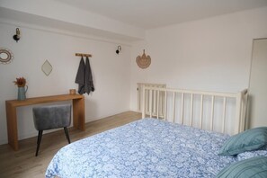 Un dormitorio con una cama, un escritorio y una silla.