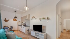 A living room with a TV, sofa, and decorative wall art. - Holiday Home '2' with Wi-Fi and Air Conditioning (El Golfo)