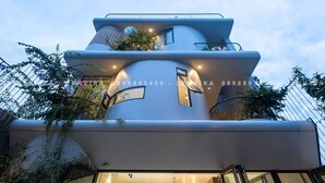 Un bâtiment moderne doté d’une conception architecturale unique, caractérisé par une façade incurvée et de nombreux balcons.