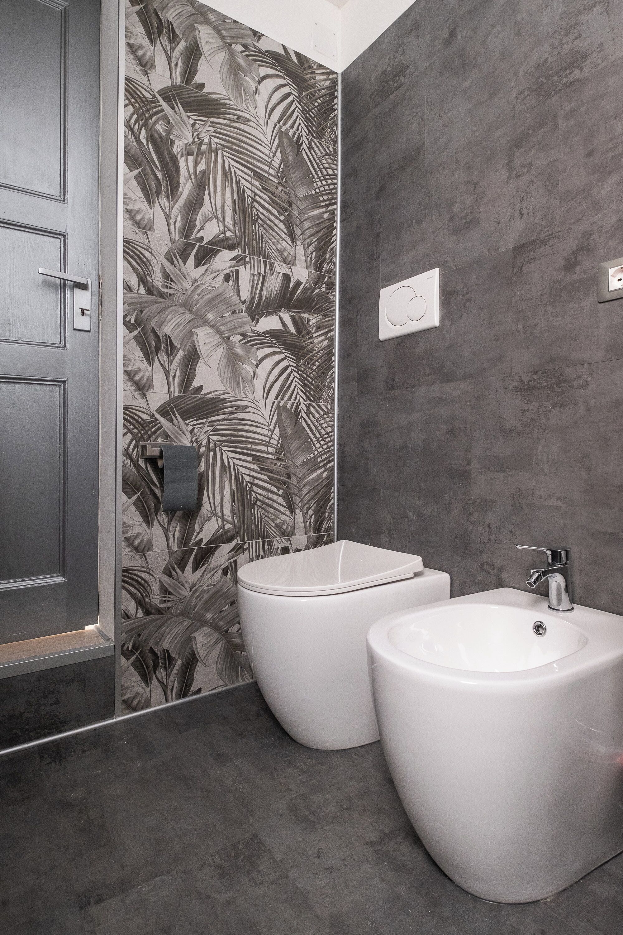 Modernilla designilla varustettu kylpyhuone, jossa on wc, bidee ja pesuallas.