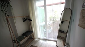 A small, sparsely furnished room with a wooden bunk bed, a small table, and a window with a view of the outside. - FETHİYE GARDEN HOUSE Apartment with private garden in the city center (Muğla)