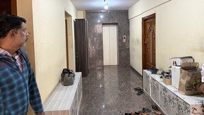 A hallway with a marble floor, a bench with a bag on it, and a door at the end. - Soothing 3-bedroom apartment with AC in Bengaluru (Bengaluru)