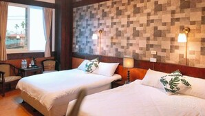 Ein Hotelzimmer mit zwei Betten, Holzboden, Fliesenwand und einem Fenster mit Vorhängen.