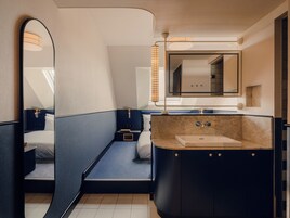 Un bagno moderno con un letto a incasso, uno specchio grande e un mobile vanità con lavabo.