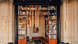 A library with bookshelves, a checkered floor, leather chairs, and a central seating area. - The Companion Vienna (Vienna)