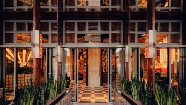 A hotel entrance with a checkered floor, glass doors, and a central staircase. - The Companion Vienna (Vienna)