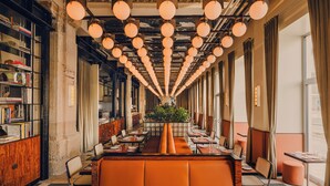 A restaurant with a long counter, booths, and a bookshelf. - The Companion Vienna (Vienna)
