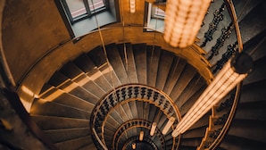 A spiral staircase with a central column, metal railings, and a handrail. - The Companion Vienna (Vienna)