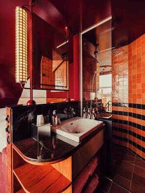 A modern bathroom with a large mirror, a sink, and a shower.