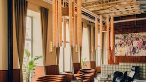 A lobby with leather sofas, a coffee table, and a large painting on the wall. - The Companion Vienna (Vienna)