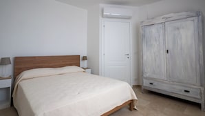 A bedroom with a bed, a wardrobe, and a nightstand. - Super cosy apartment near the sea for 6/8 people (Follonica)