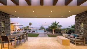 An outdoor patio with a pool, stone walls, and seating areas. - 6BR Luxe Villa w/ Infinity Pool & Ocean Views (Cabo San Lucas)