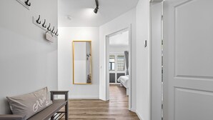 A hallway with a bench, a mirror, and a door leading to a bedroom. - Küstenglück - Shower room, covered balcony, garden furniture, TV, parking space (Damp)