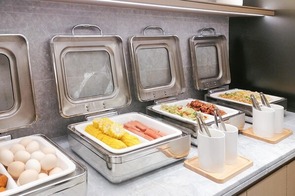 A buffet with various food items including eggs, corn, and hot dogs. - Ji Hotel Guangzhou Shayuan Metro Station (Guangzhou)