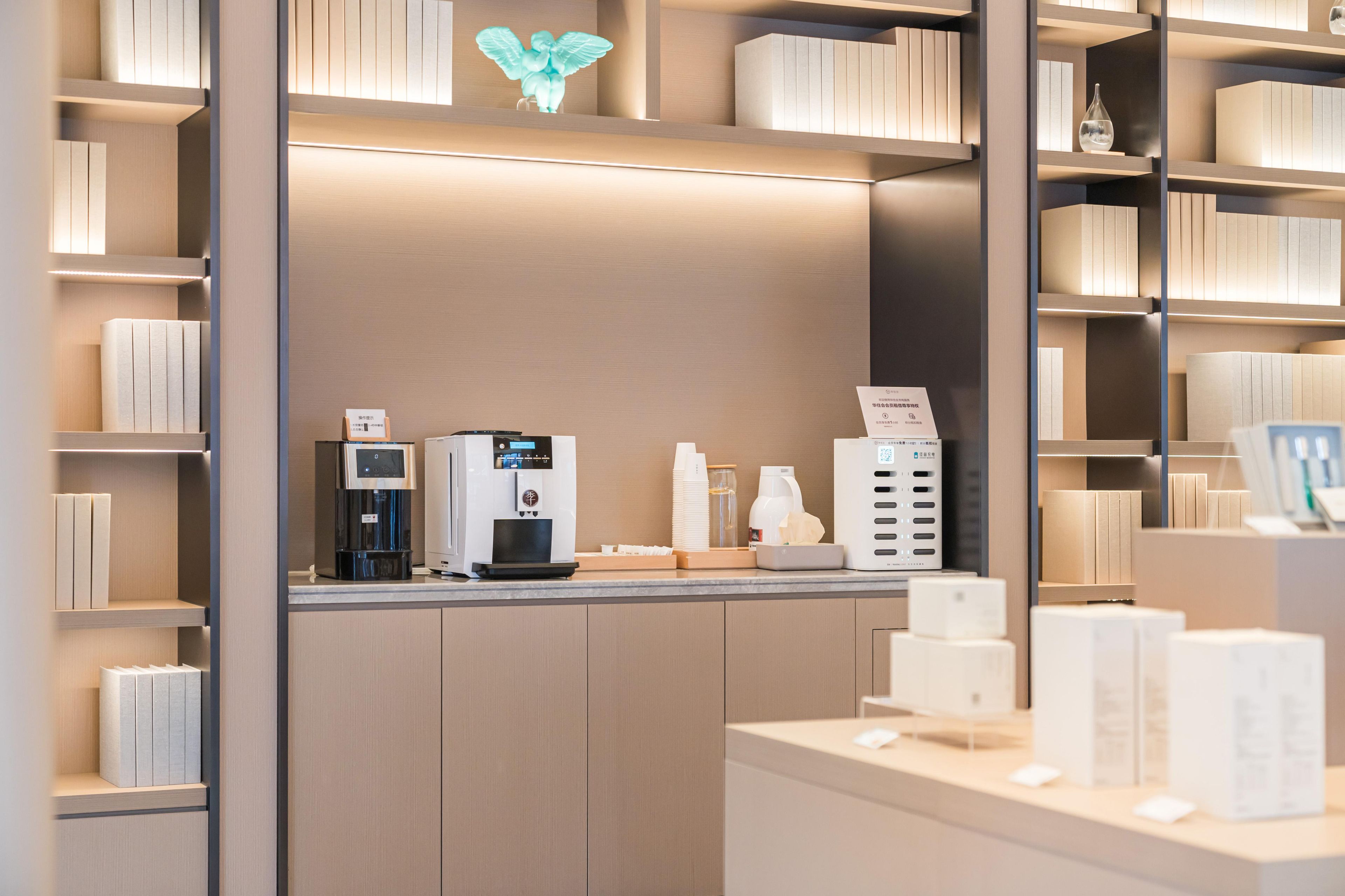 A modern, well-lit reception area with a coffee machine, a water dispenser, and a self-service kiosk.