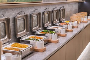 A buffet setup with various food stations, including trays of rice, vegetables, and other dishes. - Ji Hotel Guangzhou Shayuan Metro Station (Guangzhou)