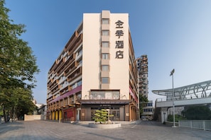 A multi-story hotel with a prominent sign indicating it is a hotel. The building has a modern design with a flat roof and large windows. - Ji Hotel Guangzhou Shayuan Metro Station (Guangzhou)
