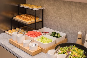 A buffet setup with various food items including pastries, fruits, and salads. - Ji Hotel Guangzhou Shayuan Metro Station (Guangzhou)