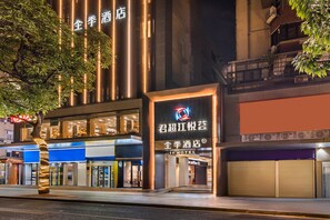 A hotel with a modern facade, illuminated signage, and a tree in front. - Ji Hotel Guangzhou Jiangnanxi Metro Station (Guangzhou)
