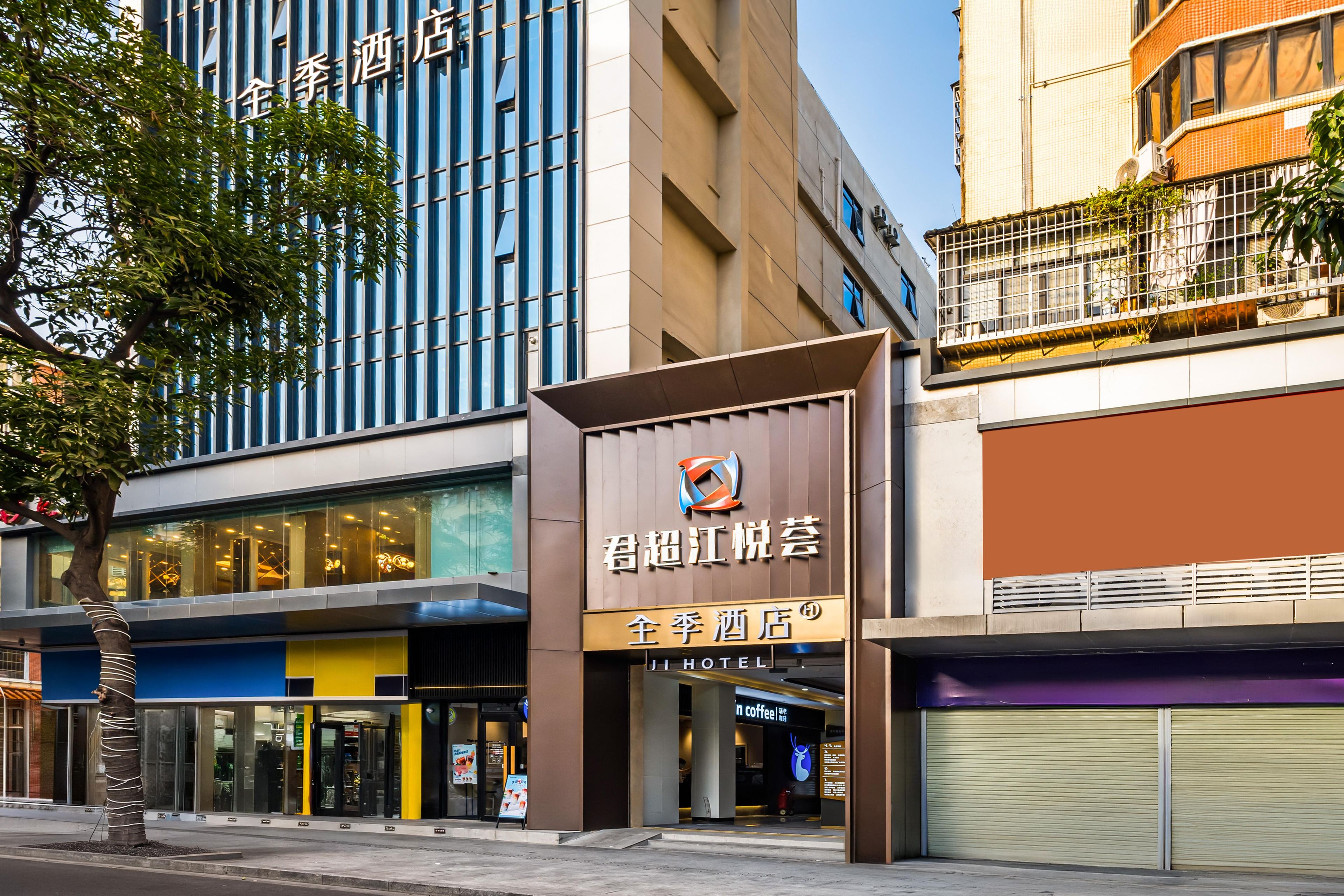 A hotel with a modern facade, large windows, and a prominent sign.