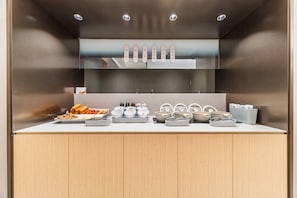 A modern kitchen with a wooden countertop, various kitchenware, and a glass display case above. - Ji Hotel Guangzhou Jiangnanxi Metro Station (Guangzhou)