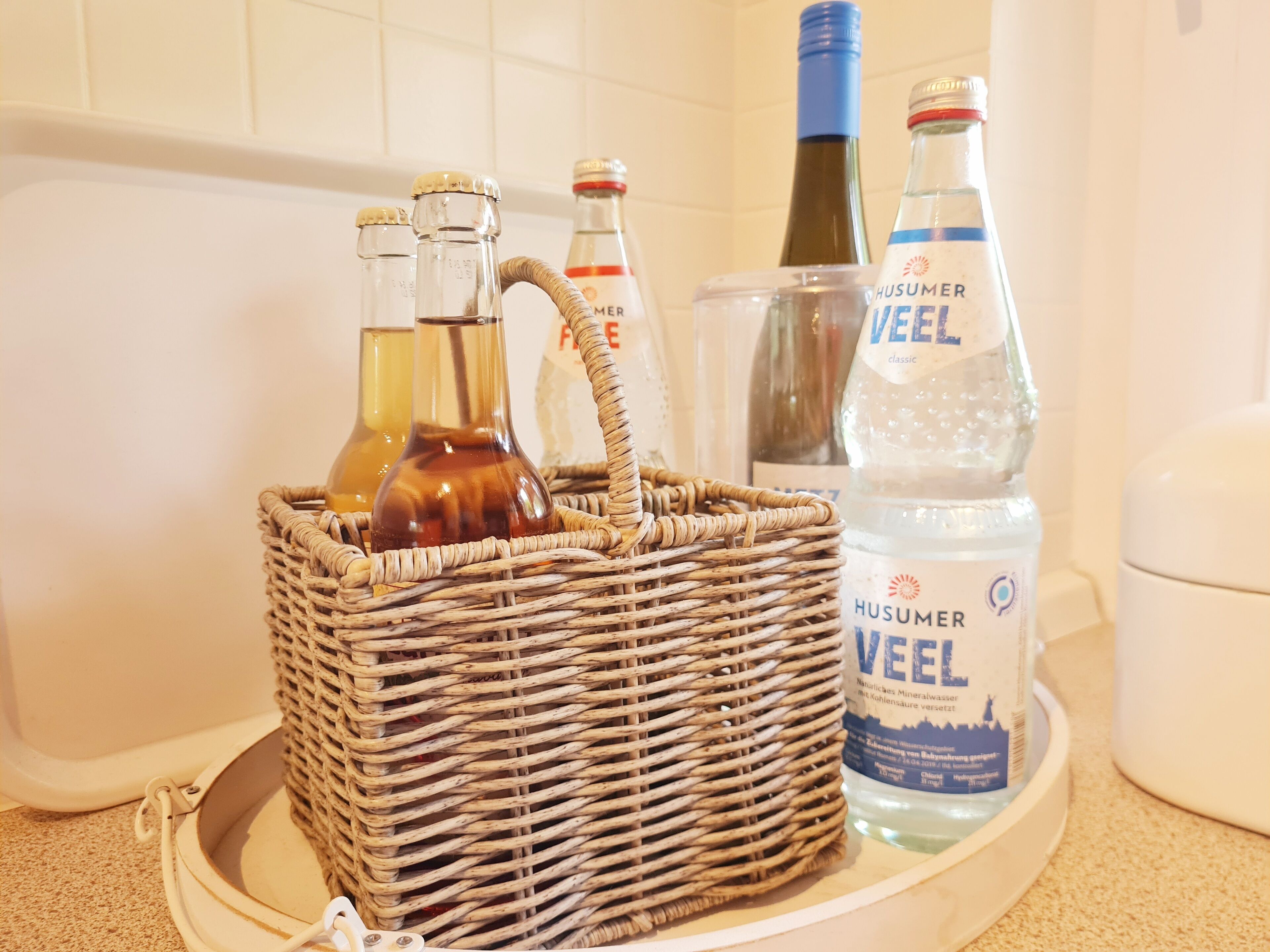 A wicker basket containing bottles on a tray.
