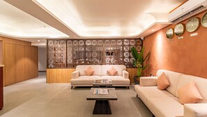 Una sala moderna con un sofá, una mesa de centro y un separador decorativo.
