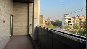 Un balcón con vistas a un paisaje urbano, con edificios y cielo despejado.