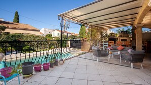 A covered outdoor area with a pool, outdoor furniture, and potted plants. - Salamandre Guest Room with Shared Pool, Wi-Fi, and Air Conditioning (Port-Saint-Louis-du-Rhône)
