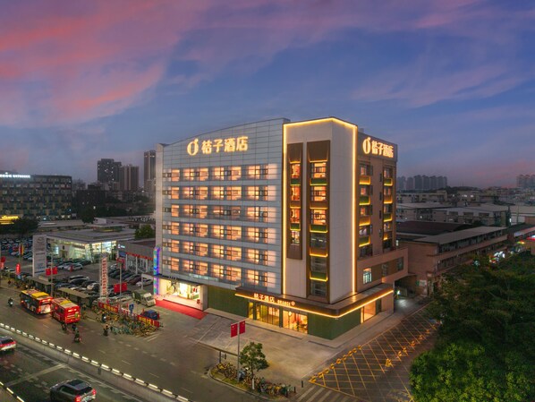 Un hotel de varios pisos con un diseño moderno, que cuenta con una entrada destacada y varios balcones.