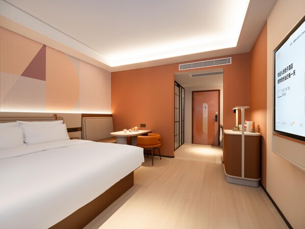 Una habitación de hotel moderna con una cama, un escritorio, una silla y una pantalla de televisión mostrando información.