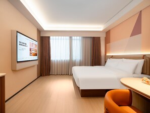 A hotel room with a bed, a desk with a chair, a television mounted on the wall, and a window with curtains. - Orange Guangzhou Panyu Chimelong Wanbo Center (Guangzhou)