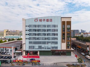 A hotel with a modern facade, multiple floors, and a prominent signage. - Orange Guangzhou Panyu Chimelong Wanbo Center (Guangzhou)