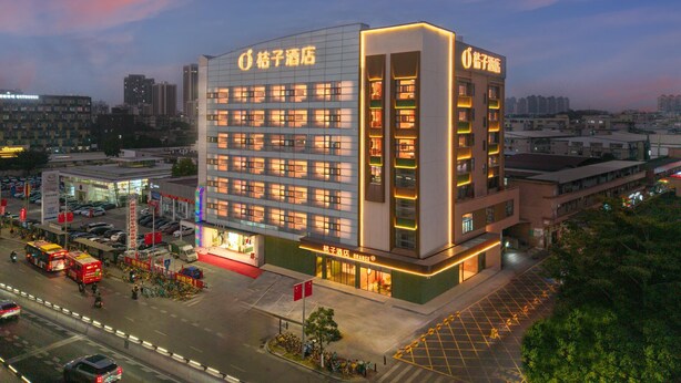 Un hotel de varios pisos con un diseño moderno, que cuenta con una entrada destacada y varios balcones.