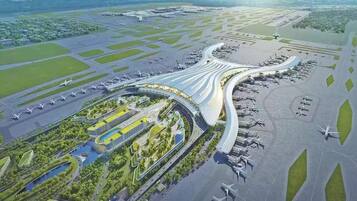An airport with multiple runways and a curved terminal building.