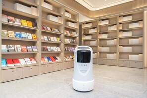 A library with bookshelves and a self-service kiosk. - Ji Hotel Guangzhou Baiyun Airport Terminal 2 (Guangzhou)